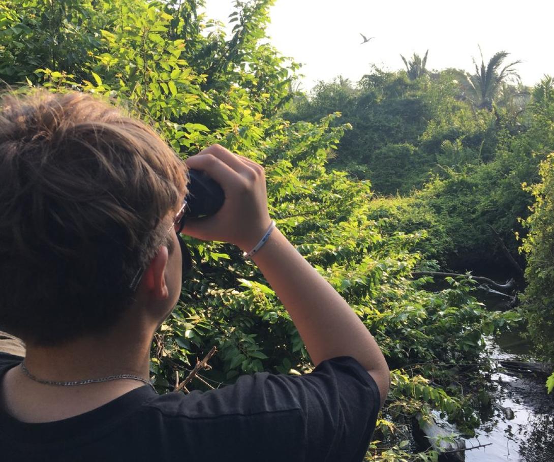 A teenager on a tailor-made volunteer trip for his school participates in a bird survey in Mexico. A high school student on a bespoke group trip with his peers observes birds in Mexico.